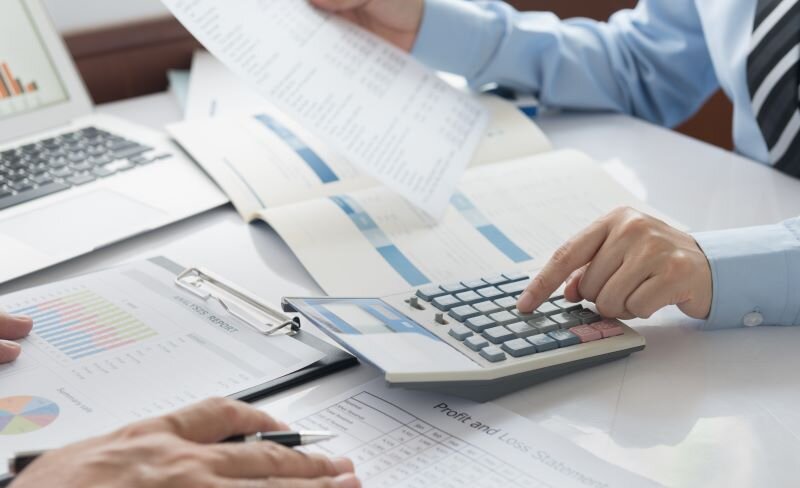 An accountant calculates the taxes before his client lists a house for sale.