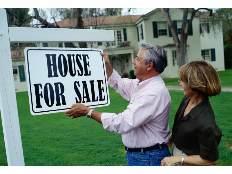 couple putting up for sale sign