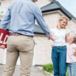 woman_with_daughter_buying_new_house_and_shaking_hand_of_male