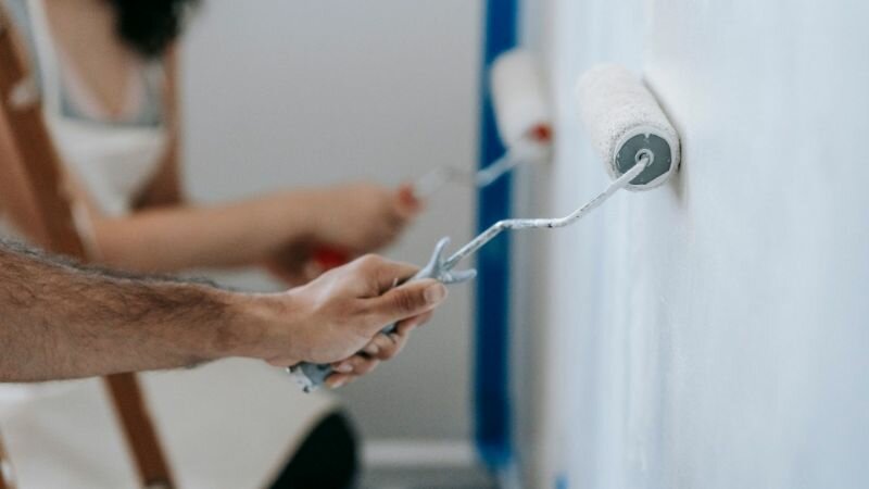 Two People Painting The Wall