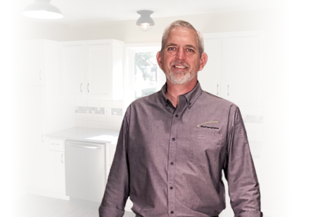 Smiling owner of company that buys inherited houses standing in remodeled kitchen