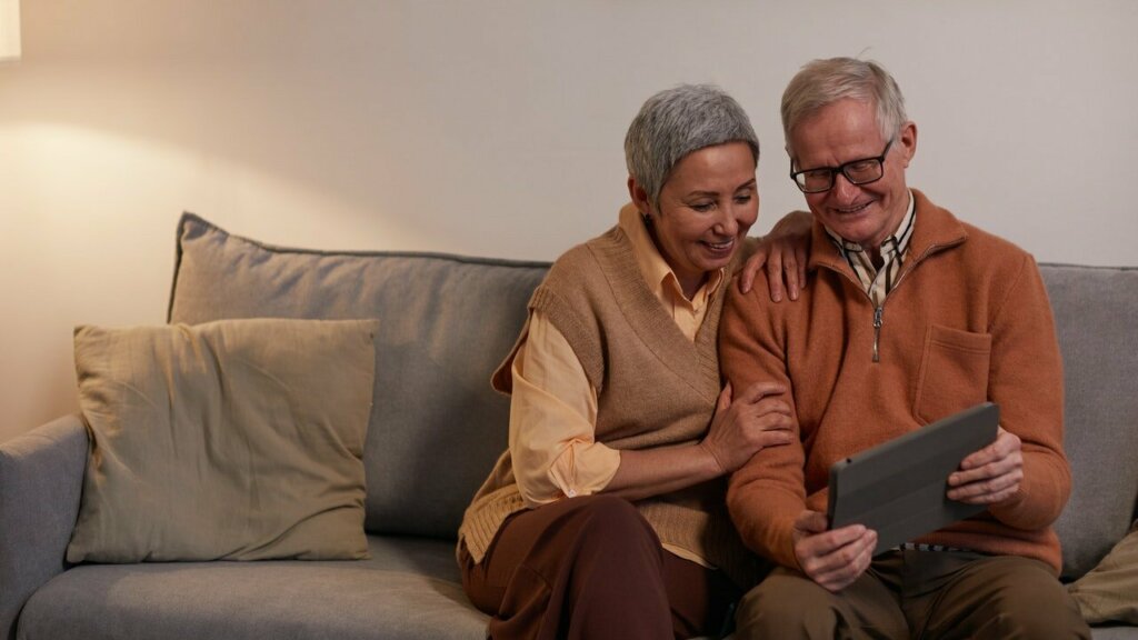 Two older adults looking at a tablet, thinking about the biggest reasons to downsize your home as a senior in Spartanburg
