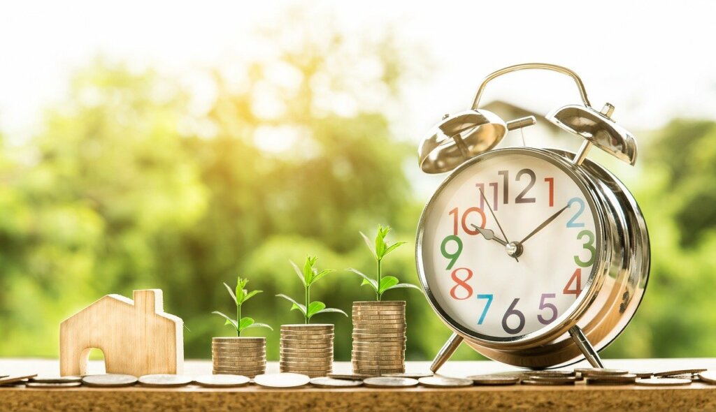 A model of a house, a clock, and coins
