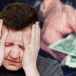 Frustrated man with head between hands and eyes closed thinking about money issues