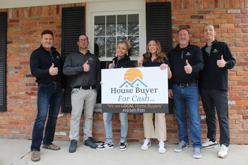 The House Buyer For Cash local team holding a company sign in front of a brick house next to a list of direct cash offer benefits.