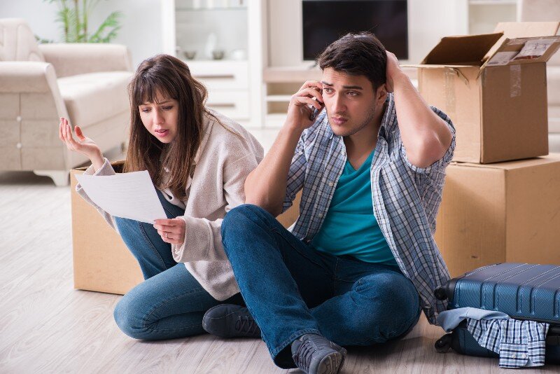 A couple arguing concerned about all the stuff they found in their new place previously owned by a hoarder.