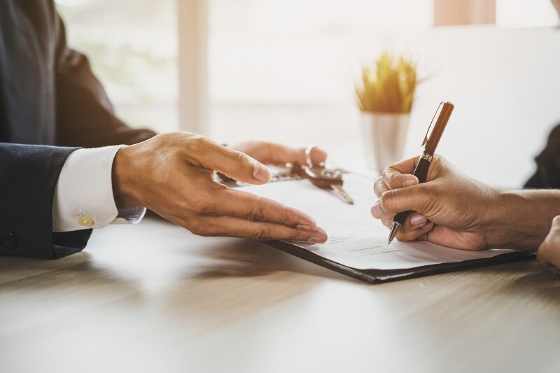 A landlord and a lawyer signing some documents.