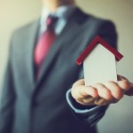 how to sell a house you inherited | businessman holding house