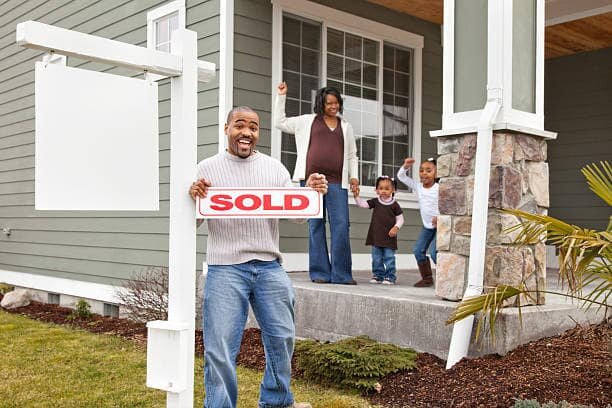 Family in Bakersfield, CA holding a SOLD sign after selling their house as-is. Sell My House Fast Bakersfield