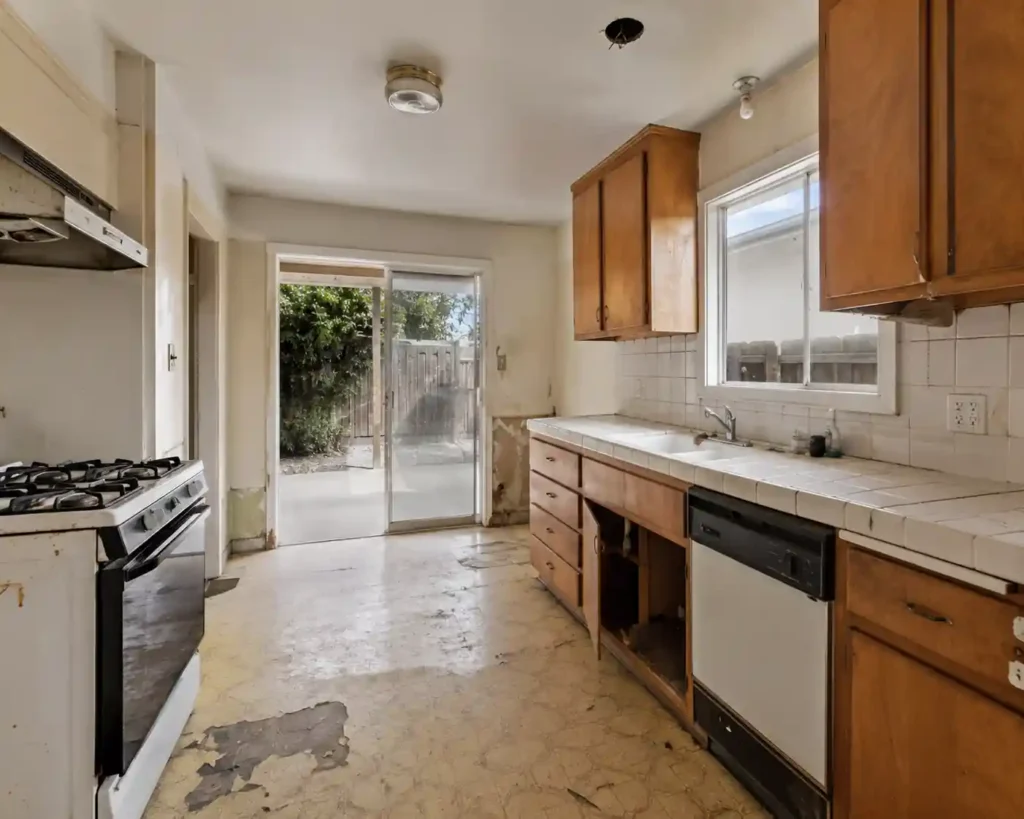 Fixer upper kitchen in Fremont CA with outdated cabinets and worn flooring for homeowners looking to sell my house fast for cash without repairs or renovations.