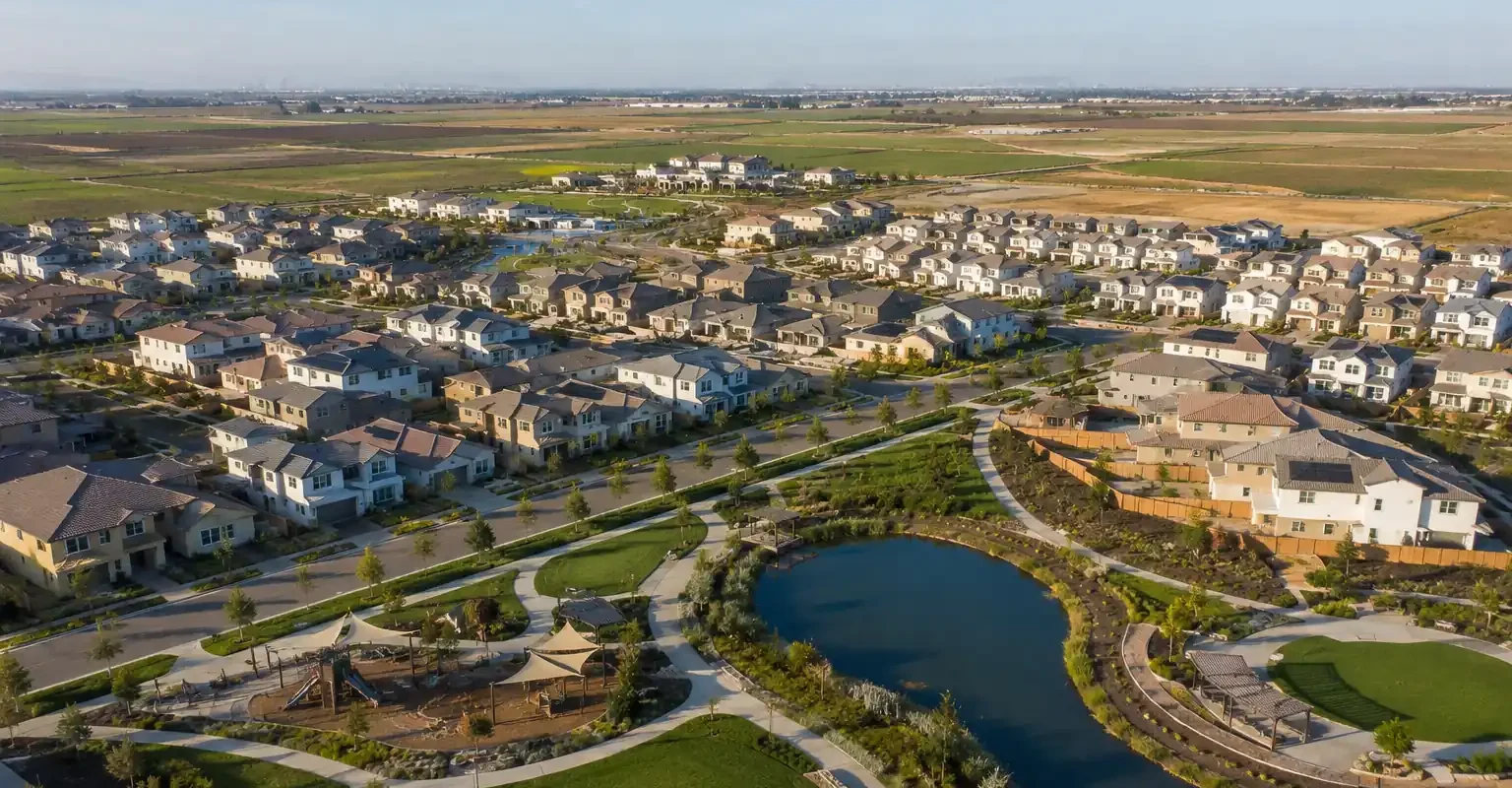 Aerial view of the Morada neighborhood in Stockton California featuring residential homes, landscaped parks, walking trails, and a pond during golden hour for sell my house fast Morada
