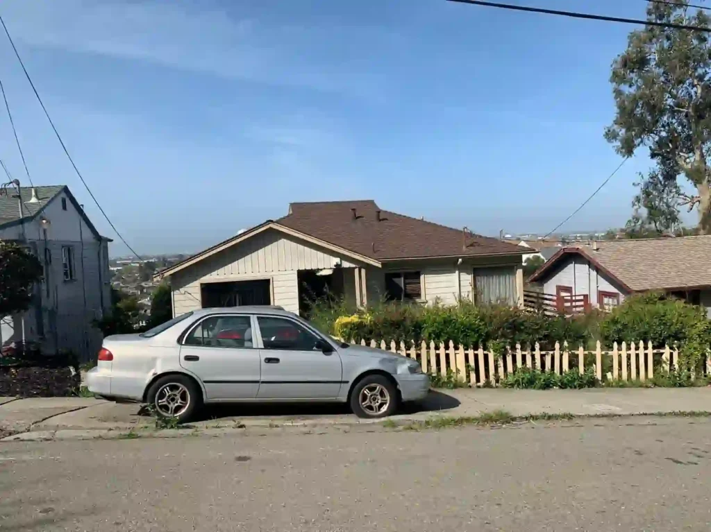 Front exterior of a home on Burr Street in East Oakland before renovation, showing the property's original condition prior to being purchased as-is by R&H Distressed Properties.