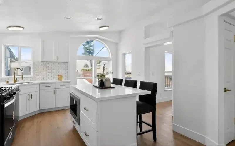 Renovated white kitchen with island in a San Jose, CA home purchased as is by R&H Distressed Properties.