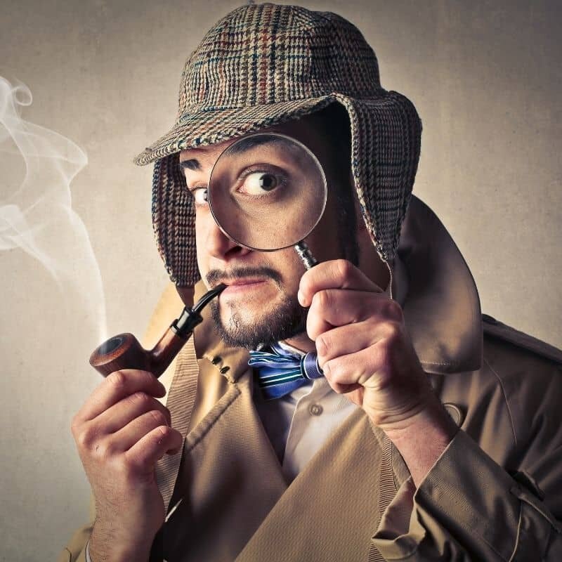 a man smoking a pipe with a magnigying glass up to his eye