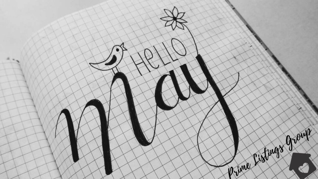 An open notebook in which it is written Hello May, Prime Listings Group with a bird and a flower drawn in. 