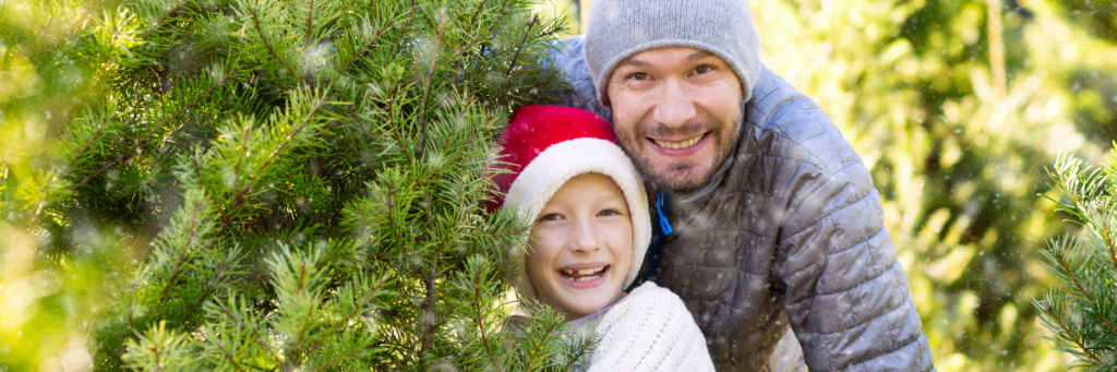 Father and young daughter picking out a Christmas tree