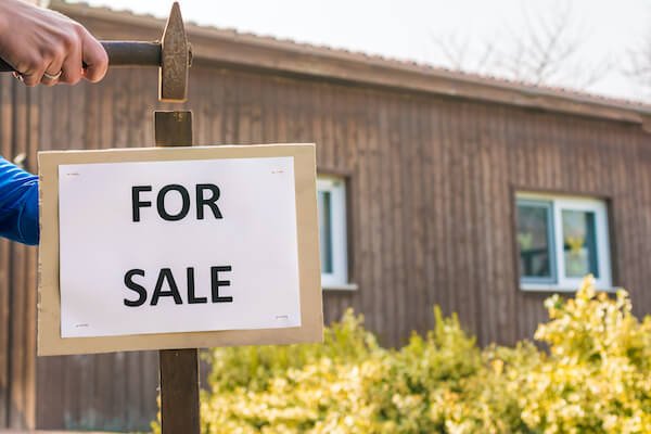 A House For Sale As-Is With A For Sale Sign In Houston
