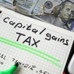 Notebook with capital gains tax sign on a table