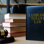 law books, a gavel and a dark grey book titled Landlord Tenant Law on an office desk