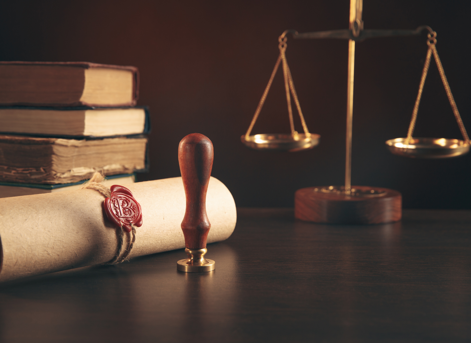 lawyer scales, official documents and a wax seal on a wooden table