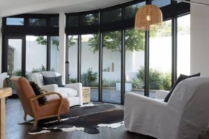 a living space with sofas and glass windows