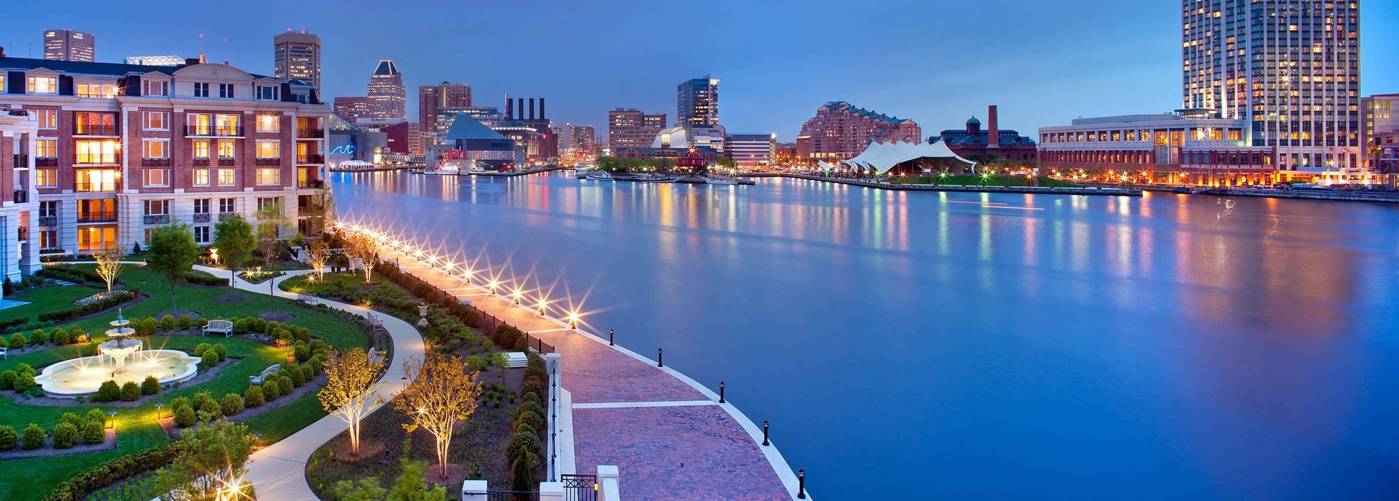 Baltimore Inner Harbor at dusk with city skyline and waterfront promenade