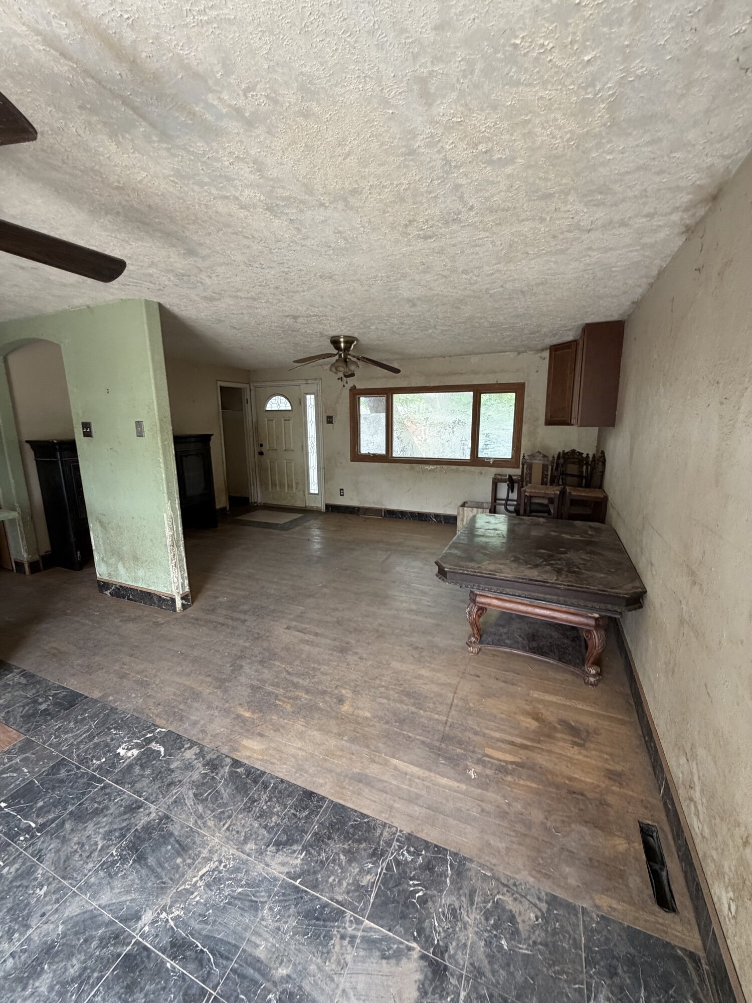 Before: living room at 1708 Jewel Dr, Longmont — worn floors, mismatched tile