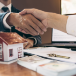Hands shaking over real estate contracts