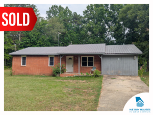 A ranch-style red brick house with a closed carport [bought by We Buy Houses in West Georgia]