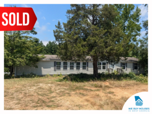 A ranch-style house with white siding, gray trim, and several front windows [bought by We Buy Houses in West Georgia]