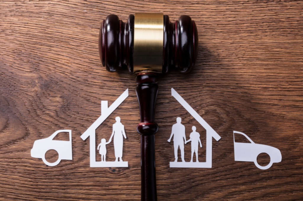 A gavel dividing silhouettes of a couple with their children, house, and car. 