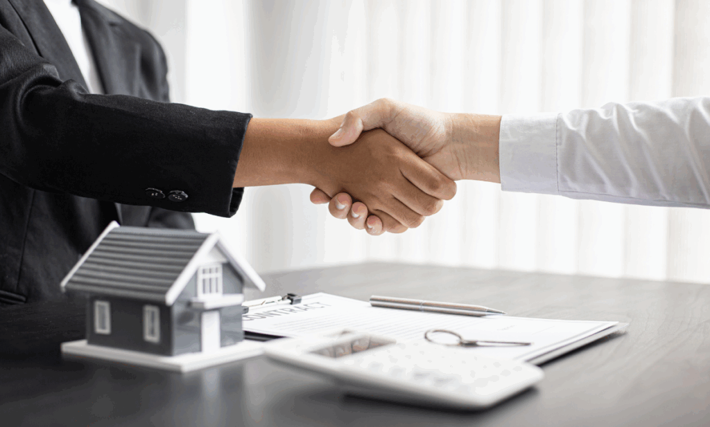 Hands shaking over a home sale contract
