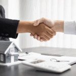 Hands shaking over a home sale contract