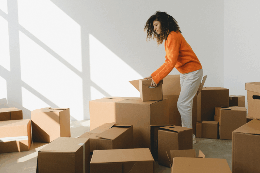A woman moving boxes out of a packed-up room