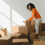 A woman moving boxes out of a packed-up room