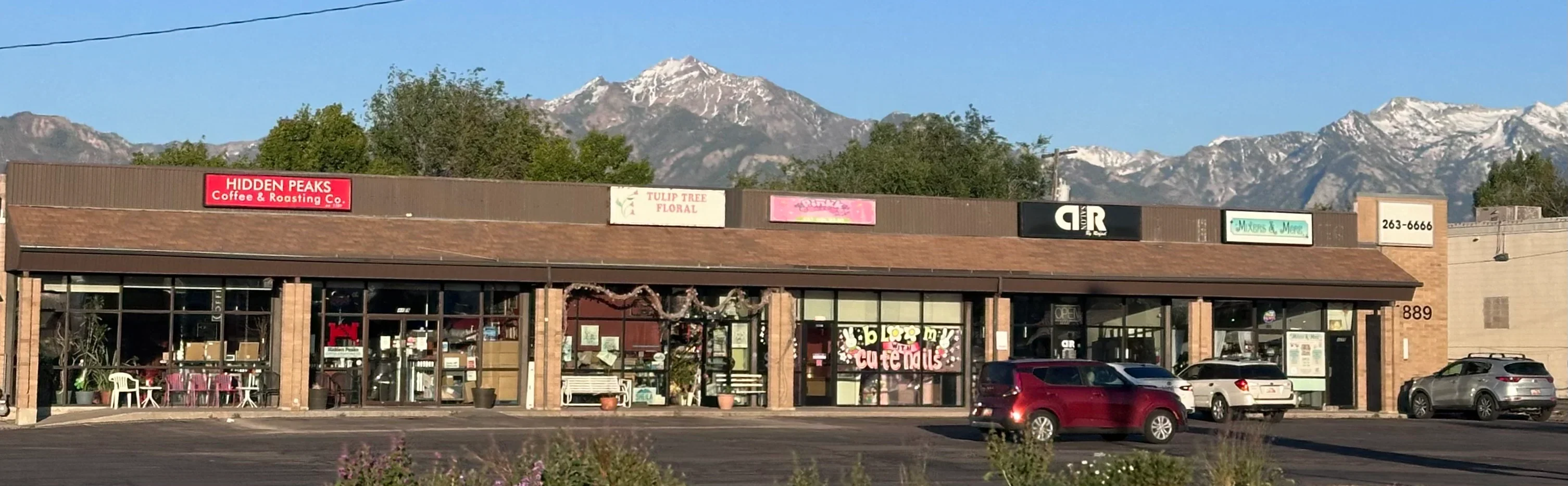 Local businesses on Murray Taylorsville Road including Hidden Peaks Coffee with snow-capped Wasatch Mountains in background — Taylorsville Utah
