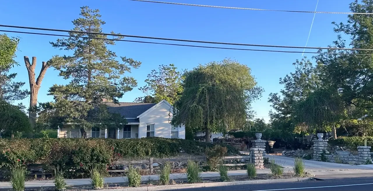 Established residential home with mature trees and stone landscaping in Taylorsville Utah — the type of property Utah Close Fast cash home buyers purchase