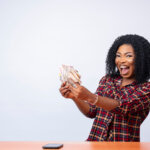 Woman excitedly holding cash with a big smile on her face