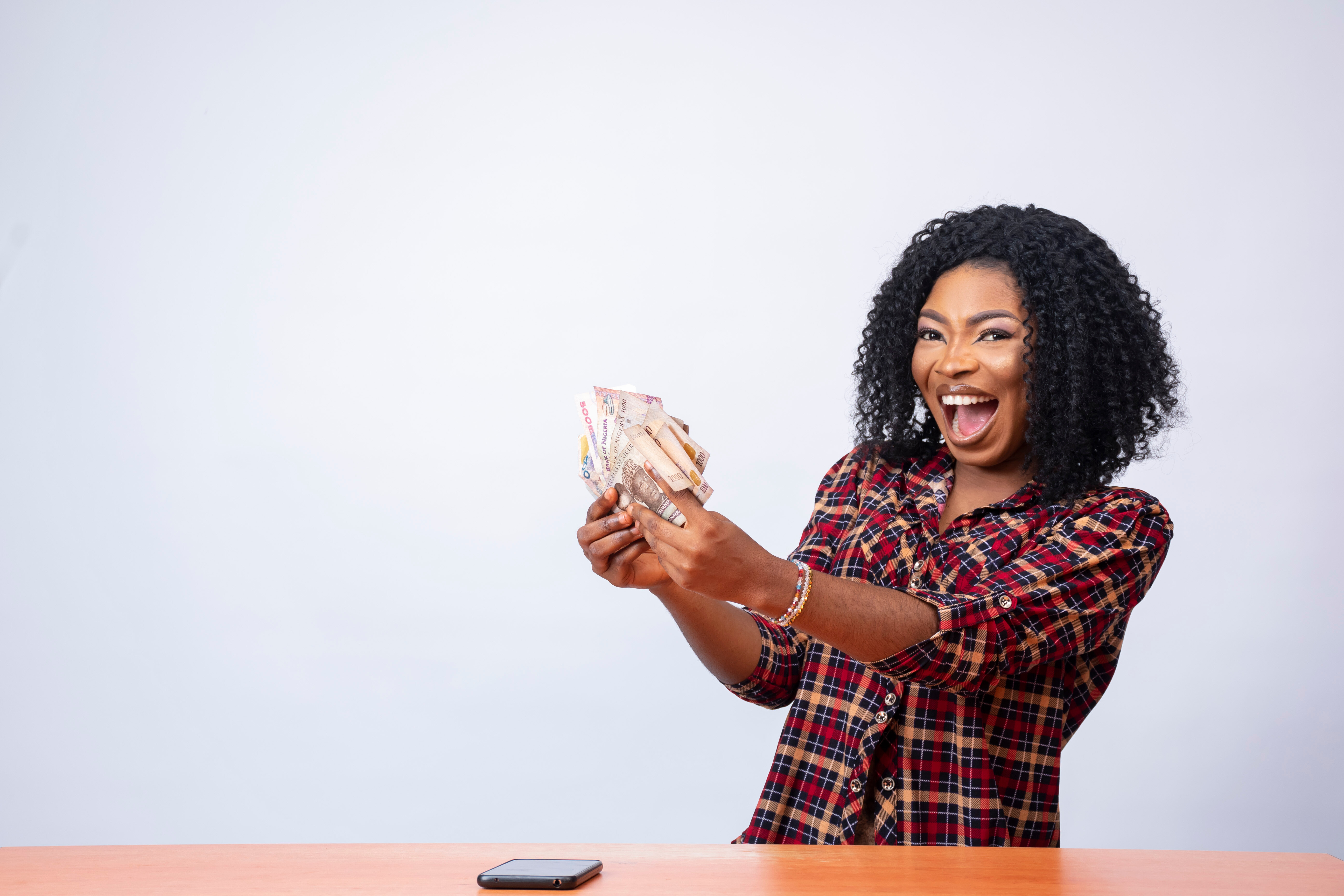 Woman excitedly holding cash with a big smile on her face