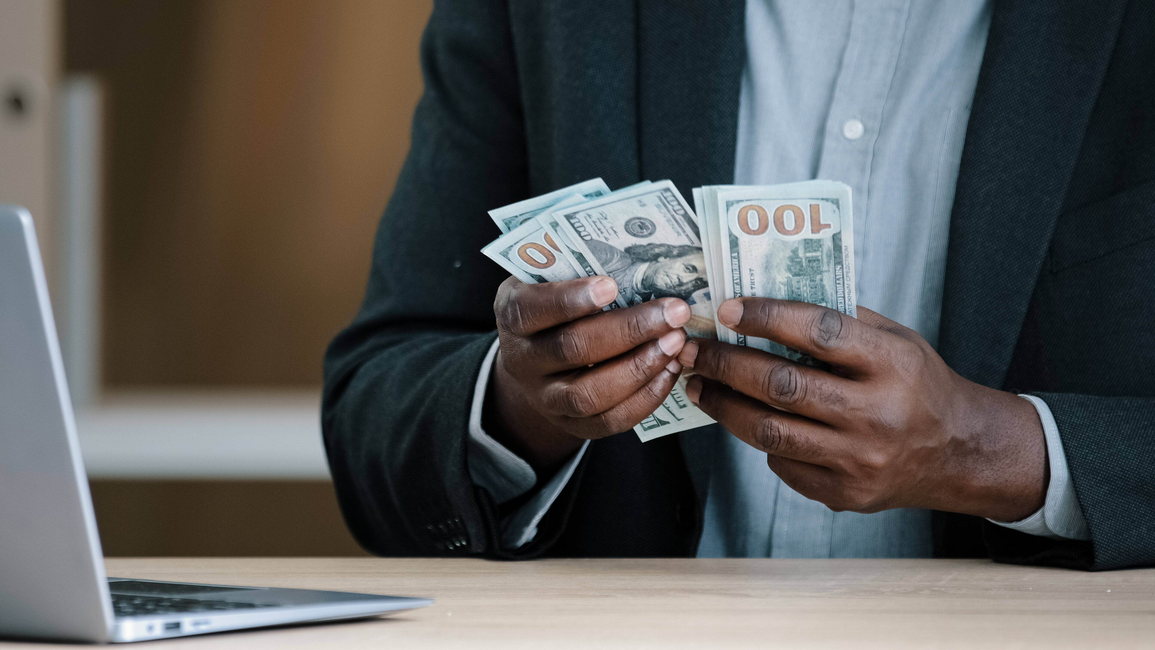 African American man holding large sum of cash bills