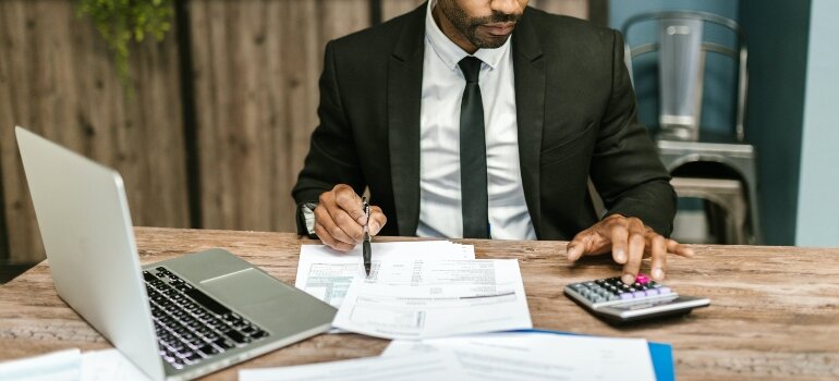 A man calculating decluttering and storage expenses