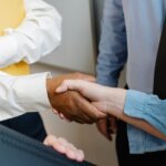 A close-up photo of two persons shaking hands.