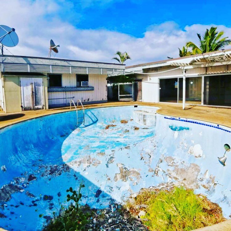 A house in Wailuku, Hawaii that needs major repairs due to termite damage and plants growing in the pool. 