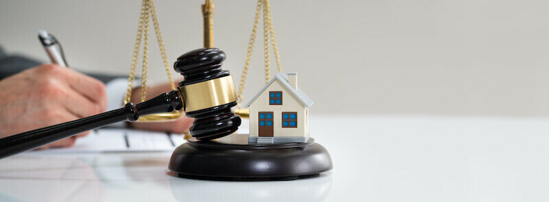 hand with gavel and model house - Minneapolis House Selling Laws