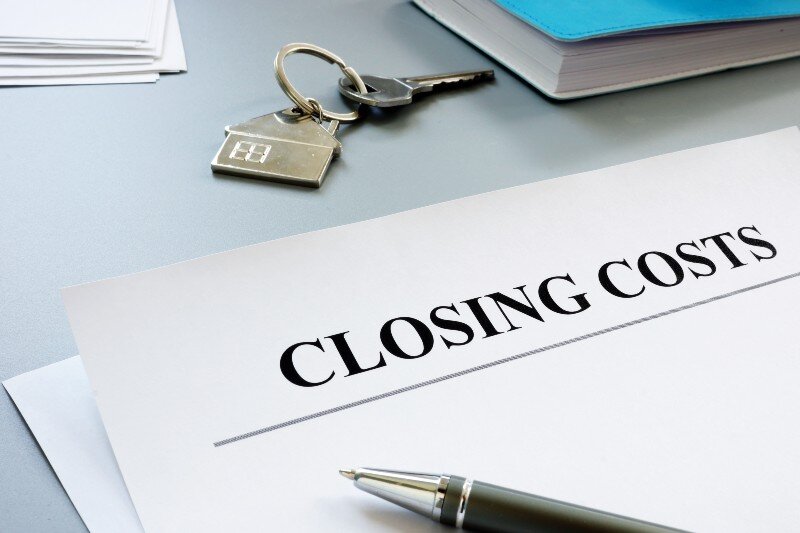 A house key, a note pad, and some files labeled ‘closing costs’.