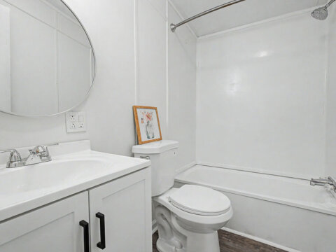 Updated bathroom interior displaying clean white finishes in the owner financed home in Greenville.