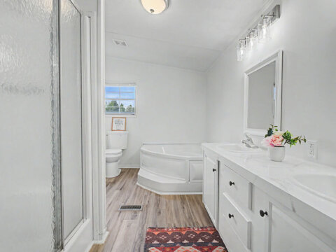 Master bathroom featuring a garden tub, separate shower, and double sinks at 105 Glenmont Ln.