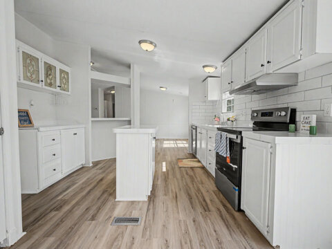 Bright kitchen with central island and pass-through window inside the owner financed home at 105 Glenmont Ln.