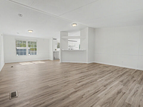Bright open floor plan living room with modern laminate flooring in the owner financed home at 105 Glenmont Ln.