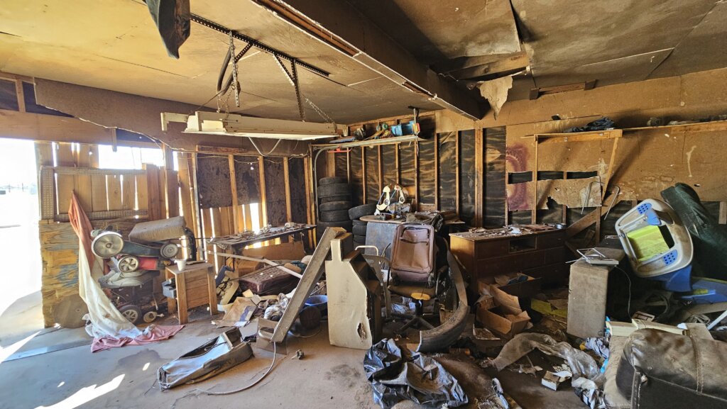 Cluttered Hoarder House Garage In Lubbock Texas With Broken Furniture, Trash, And Piles Of Belongings Left Behind, Showing That Cash Home Buyers Purchase Properties As-Is And Help Homeowners Sell Your House Fast For Cash Without Cleaning Or Repairs